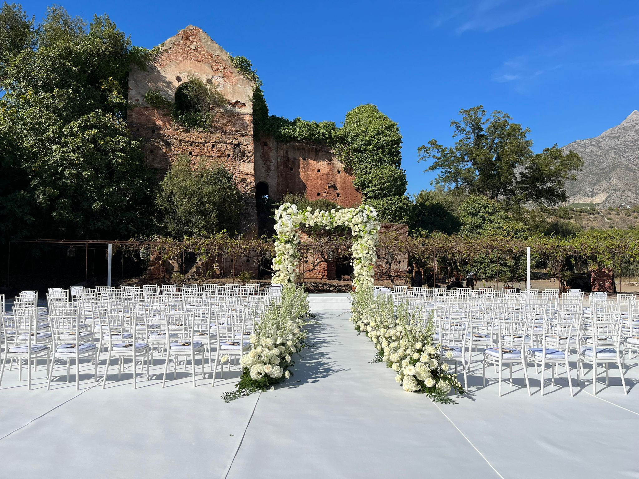 Entrada da noiva com a nave repleta de flores naturais como rosas, delphinium é hortênsias